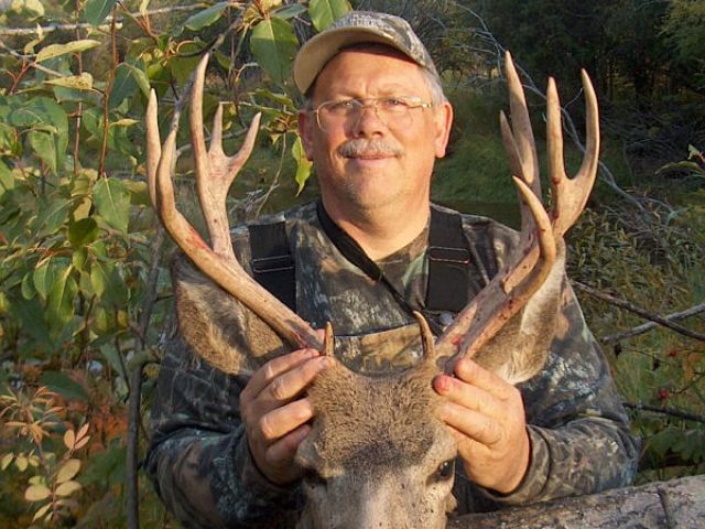 His second buck, 22 inches wide and 12 points. We tracked this trophy mule deer over a mile. Out of arrows, Art borrowed my hunting knife and jumped for his staggering wounded trophy. One flip on the buck\'s antlers and the animal landed on his side. A moment later we were taking photos.