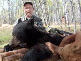 Archery hunter, Brent, with his baited Black Bear. While feeding out of a barrel filled with our special recipe of bear food this guy had no idea Brent's arrow was on it's way and he ended up being a rug for our hunter. With a very high color % of bears in our area hunters often get chances at all colors of bears.