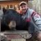 Archery hunter, Cory, in a close up with his monster bear. Many serious photos were taken too. A sharp eye and an accurate shot and this bear didn\'t take more than a few steps once he had been arrowed. The camp of 5 clients all tagged their trophy bear giving us another 100% on a non-baited hunt.